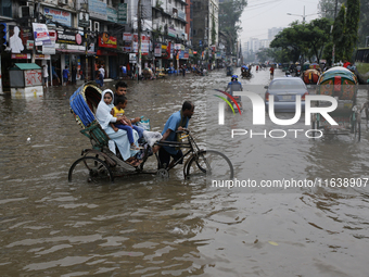 Rickshaw pullers make their way through a waterlogged street during rainfall in Dhaka, Bangladesh, on September 26, 2024. The flash flood hi...