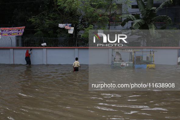 Residents walk through a waterlogged street after heavy rainfall in Dhaka, Bangladesh, on October 5, 2024. The flash flood hits several area...