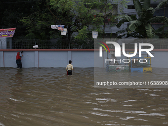 Residents walk through a waterlogged street after heavy rainfall in Dhaka, Bangladesh, on October 5, 2024. The flash flood hits several area...