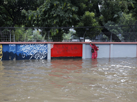 A woman walks through a waterlogged street after heavy rainfall in Dhaka, Bangladesh, on October 5, 2024. The flash flood hits several areas...