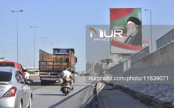 Workers hang billboards bearing a portrait of slain Lebanese Hezbollah Leader Hassan Nasrallah along the airport highway in Beirut, Lebanon,...