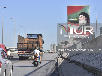 Workers hang billboards bearing a portrait of slain Lebanese Hezbollah Leader Hassan Nasrallah along the airport highway in Beirut, Lebanon,...