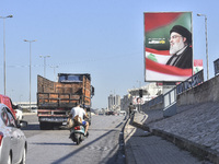 Workers hang billboards bearing a portrait of slain Lebanese Hezbollah Leader Hassan Nasrallah along the airport highway in Beirut, Lebanon,...