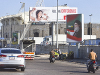 Workers hang billboards bearing a portrait of slain Lebanese Hezbollah Leader Hassan Nasrallah along the airport highway in Beirut, Lebanon,...