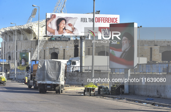 Workers hang billboards bearing a portrait of slain Lebanese Hezbollah Leader Hassan Nasrallah along the airport highway in Beirut, Lebanon,...