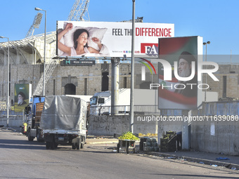 Workers hang billboards bearing a portrait of slain Lebanese Hezbollah Leader Hassan Nasrallah along the airport highway in Beirut, Lebanon,...