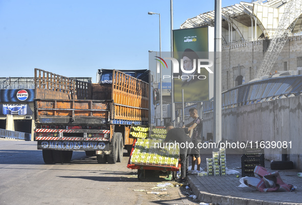 Workers hang billboards bearing a portrait of slain Lebanese Hezbollah Leader Hassan Nasrallah along the airport highway in Beirut, Lebanon,...