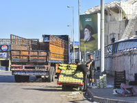 Workers hang billboards bearing a portrait of slain Lebanese Hezbollah Leader Hassan Nasrallah along the airport highway in Beirut, Lebanon,...