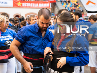 A couple prepares to perform a human tower during the Concurs de Castells competition in Tarragona, Spain, on October 5, 2024. (