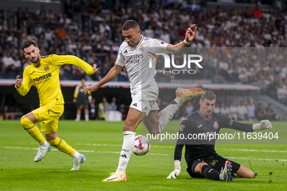 Kylian Mbappe of Real Madrid CF (C) is in action with the ball during the La Liga EA Sports 2024/25 football match between Real Madrid CF an...