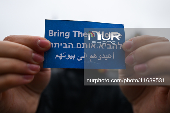 KRAKOW, POLAND - OCTOBER 5:
A pro-Israeli supporter holds a sign reading 'Bring Them Home' as pro-Palestinian activists rally in Krakow's UN...