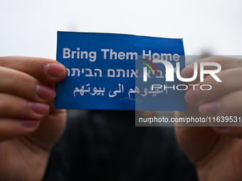 KRAKOW, POLAND - OCTOBER 5:
A pro-Israeli supporter holds a sign reading 'Bring Them Home' as pro-Palestinian activists rally in Krakow's UN...