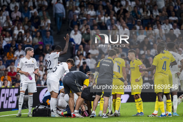 A large group of players from both teams gathers around the injured player Daniel Carvajal of Real Madrid CF, who is on the ground during th...