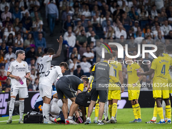 A large group of players from both teams gathers around the injured player Daniel Carvajal of Real Madrid CF, who is on the ground during th...