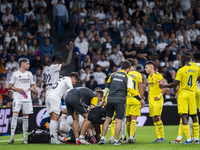 A large group of players from both teams gathers around the injured player Daniel Carvajal of Real Madrid CF, who is on the ground during th...