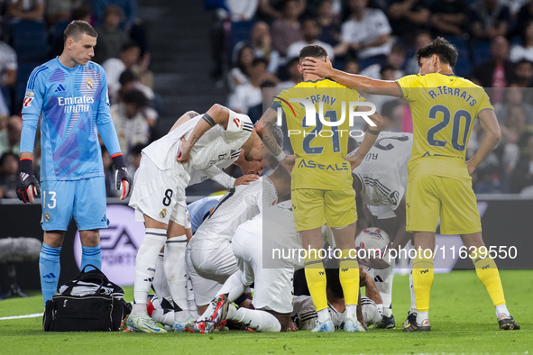 A large group of players from both teams gathers around the injured player Daniel Carvajal of Real Madrid CF, who is on the ground during th...