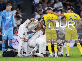 A large group of players from both teams gathers around the injured player Daniel Carvajal of Real Madrid CF, who is on the ground during th...