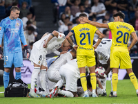 A large group of players from both teams gathers around the injured player Daniel Carvajal of Real Madrid CF, who is on the ground during th...