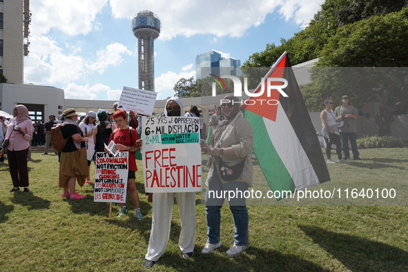 Women hold a Palestine flag during a demonstration in solidarity with Palestinian people at The Grassy Knoll to mark the first anniversary o...