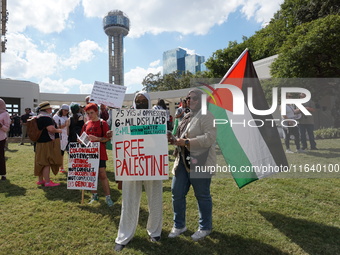 Women hold a Palestine flag during a demonstration in solidarity with Palestinian people at The Grassy Knoll to mark the first anniversary o...