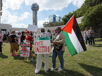 Women hold a Palestine flag during a demonstration in solidarity with Palestinian people at The Grassy Knoll to mark the first anniversary o...