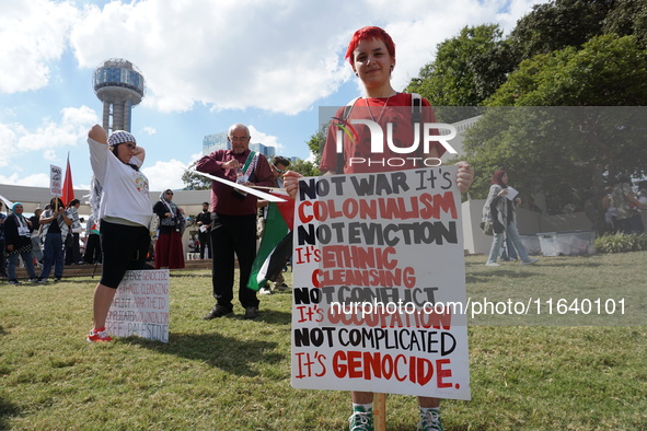 A person holds a placard during a demonstration in solidarity with Palestinian people at The Grassy Knoll to mark the first anniversary of t...