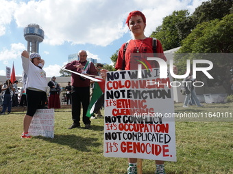 A person holds a placard during a demonstration in solidarity with Palestinian people at The Grassy Knoll to mark the first anniversary of t...