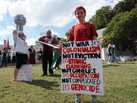 A person holds a placard during a demonstration in solidarity with Palestinian people at The Grassy Knoll to mark the first anniversary of t...