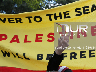 A woman makes the victory sign during a demonstration in solidarity with Palestinian people at The Grassy Knoll to mark the first anniversar...