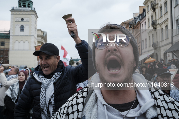 People take part in a protest in support of Palestine, in Warsaw, Poland, on October 5, 2024. Protesters march from the city center to the U...