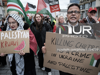 People take part in a protest in support of Palestine, in Warsaw, Poland, on October 5, 2024. Protesters march from the city center to the U...