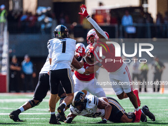 Purdue quarterback Hudson Card #1 is pressured by Wisconsin Badgers outside linebacker Darryl Peterson #17 at Camp Randall Stadium in Madiso...