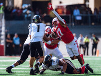 Purdue quarterback Hudson Card #1 is pressured by Wisconsin Badgers outside linebacker Darryl Peterson #17 at Camp Randall Stadium in Madiso...