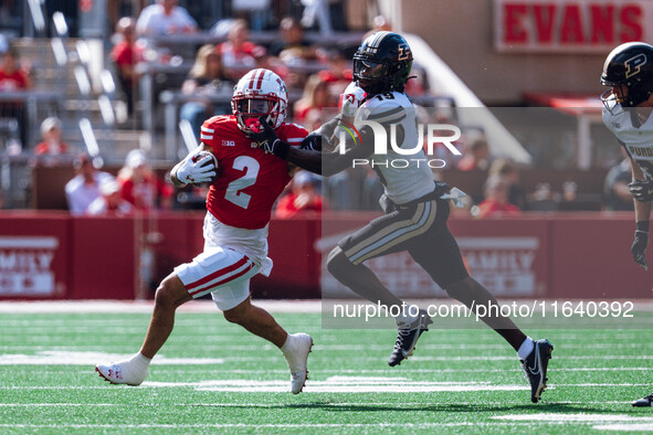 Wisconsin Badgers wide receiver Trech Kekahuna #2 gives a stiff arm to Purdue defensive back Botros Alisandro #19 at Camp Randall Stadium in...