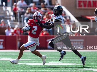 Wisconsin Badgers wide receiver Trech Kekahuna #2 gives a stiff arm to Purdue defensive back Botros Alisandro #19 at Camp Randall Stadium in...