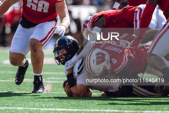 Purdue Boilermaker quarterback Hudson Card #1 is taken down by Wisconsin Badgers outside linebacker John Pius #0 at Camp Randall Stadium in...