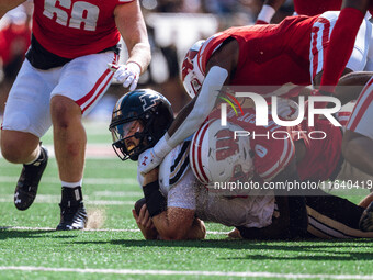 Purdue Boilermaker quarterback Hudson Card #1 is taken down by Wisconsin Badgers outside linebacker John Pius #0 at Camp Randall Stadium in...