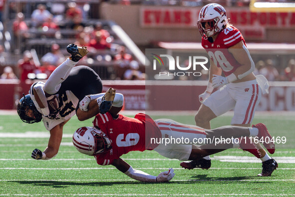 Wisconsin Badgers cornerback Xavier Lucas #6 sends Purdue running back Devin Mockobee #45 airborne at Camp Randall Stadium in Madison, Wisco...