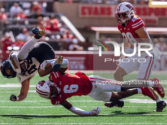 Wisconsin Badgers cornerback Xavier Lucas #6 sends Purdue running back Devin Mockobee #45 airborne at Camp Randall Stadium in Madison, Wisco...