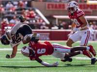 Wisconsin Badgers cornerback Xavier Lucas #6 sends Purdue running back Devin Mockobee #45 airborne at Camp Randall Stadium in Madison, Wisco...