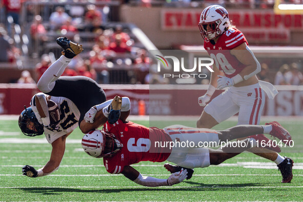 Wisconsin Badgers cornerback Xavier Lucas #6 sends Purdue running back Devin Mockobee #45 airborne at Camp Randall Stadium in Madison, Wisco...