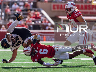 Wisconsin Badgers cornerback Xavier Lucas #6 sends Purdue running back Devin Mockobee #45 airborne at Camp Randall Stadium in Madison, Wisco...