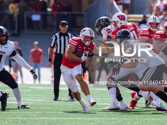 Wisconsin Badgers running back Cade Yacamelli #25 gives a stiff arm against the Purdue Boilermakers at Camp Randall Stadium in Madison, Wisc...