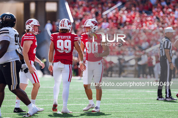 Wisconsin Badgers kicker Nathanial Vakos #90 celebrates with Cayson Pfeiffer #99 and Gavin Meyers #28 against the Purdue Boilermakers at Cam...