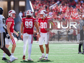 Wisconsin Badgers kicker Nathanial Vakos #90 celebrates with Cayson Pfeiffer #99 and Gavin Meyers #28 against the Purdue Boilermakers at Cam...