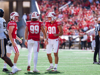 Wisconsin Badgers kicker Nathanial Vakos #90 celebrates with Cayson Pfeiffer #99 and Gavin Meyers #28 against the Purdue Boilermakers at Cam...