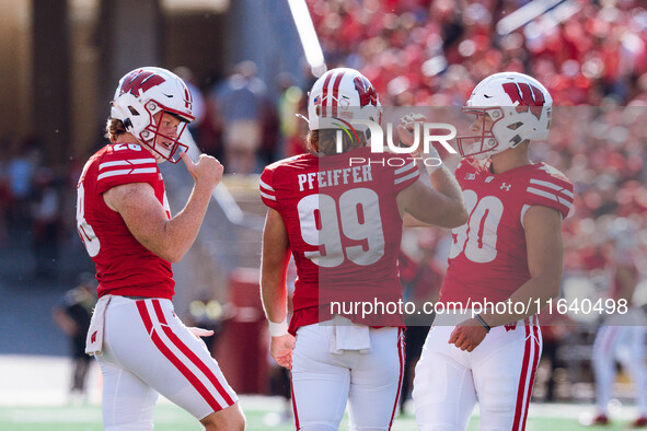 Wisconsin Badgers kicker Nathanial Vakos #90 celebrates with Cayson Pfeiffer #99 and Gavin Meyers #28 against the Purdue Boilermakers at Cam...