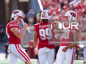 Wisconsin Badgers kicker Nathanial Vakos #90 celebrates with Cayson Pfeiffer #99 and Gavin Meyers #28 against the Purdue Boilermakers at Cam...