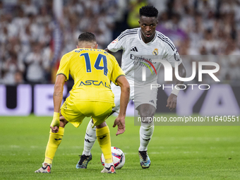 Vinicius Junior of Real Madrid CF (right) is in action with the ball against Santi Comesana of Villarreal CF (left) during the La Liga EA Sp...