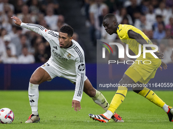 Jude Bellingham of Real Madrid CF (L) is in action with the ball against Pape Gueye of Villarreal CF (R) during the La Liga EA Sports 2024/2...